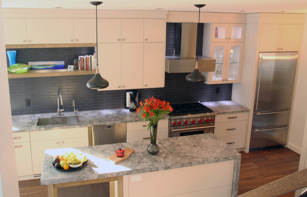 Example of a minimalist single-wall eat-in kitchen design in Toronto with a drop-in sink, flat-panel cabinets, white cabinets, soapstone countertops, blue backsplash, porcelain backsplash and stainless steel appliances