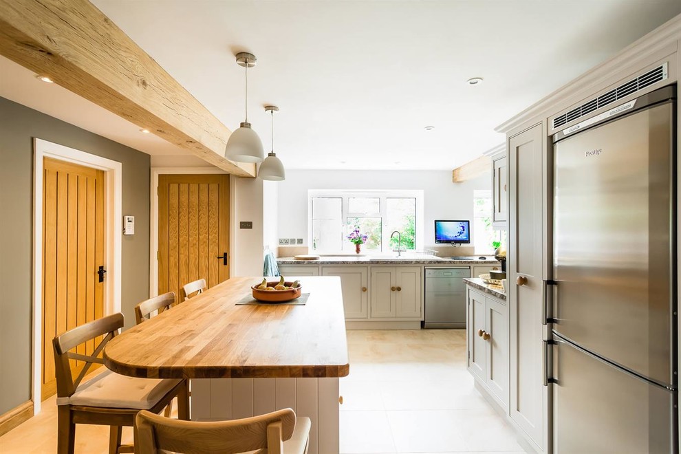 Inspiration for a medium sized classic u-shaped kitchen/diner in Oxfordshire with a single-bowl sink, beaded cabinets, grey cabinets, laminate countertops, beige splashback, stainless steel appliances and travertine flooring.