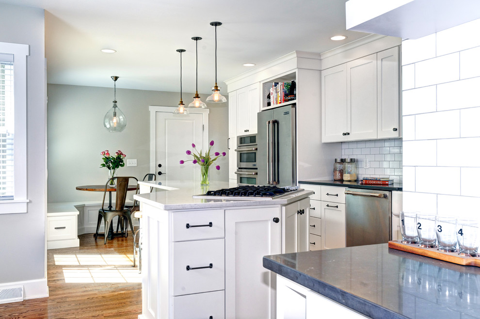 Example of a minimalist kitchen design in Columbus with white cabinets and white backsplash
