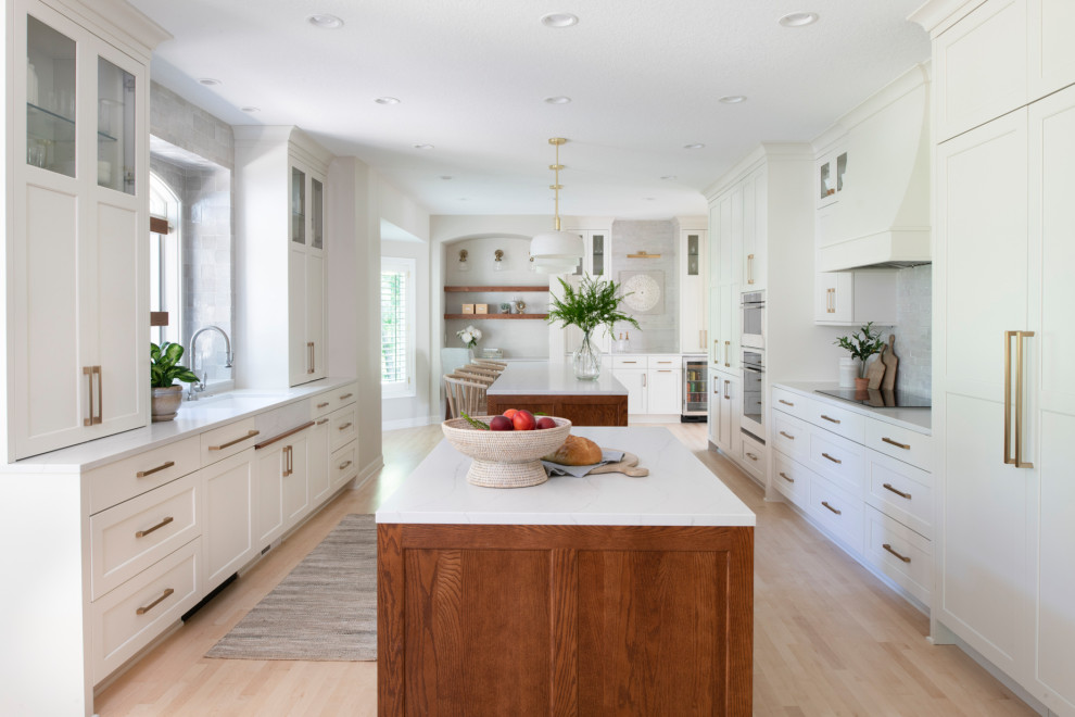 Inspiration for a large classic kitchen/diner in Minneapolis with a single-bowl sink, shaker cabinets, engineered stone countertops, integrated appliances, multiple islands and white worktops.