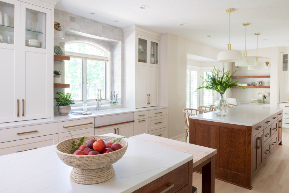 Inspiration for a large transitional u-shaped light wood floor and beige floor eat-in kitchen remodel in Minneapolis with a single-bowl sink, shaker cabinets, quartz countertops, paneled appliances, two islands, white countertops and gray backsplash