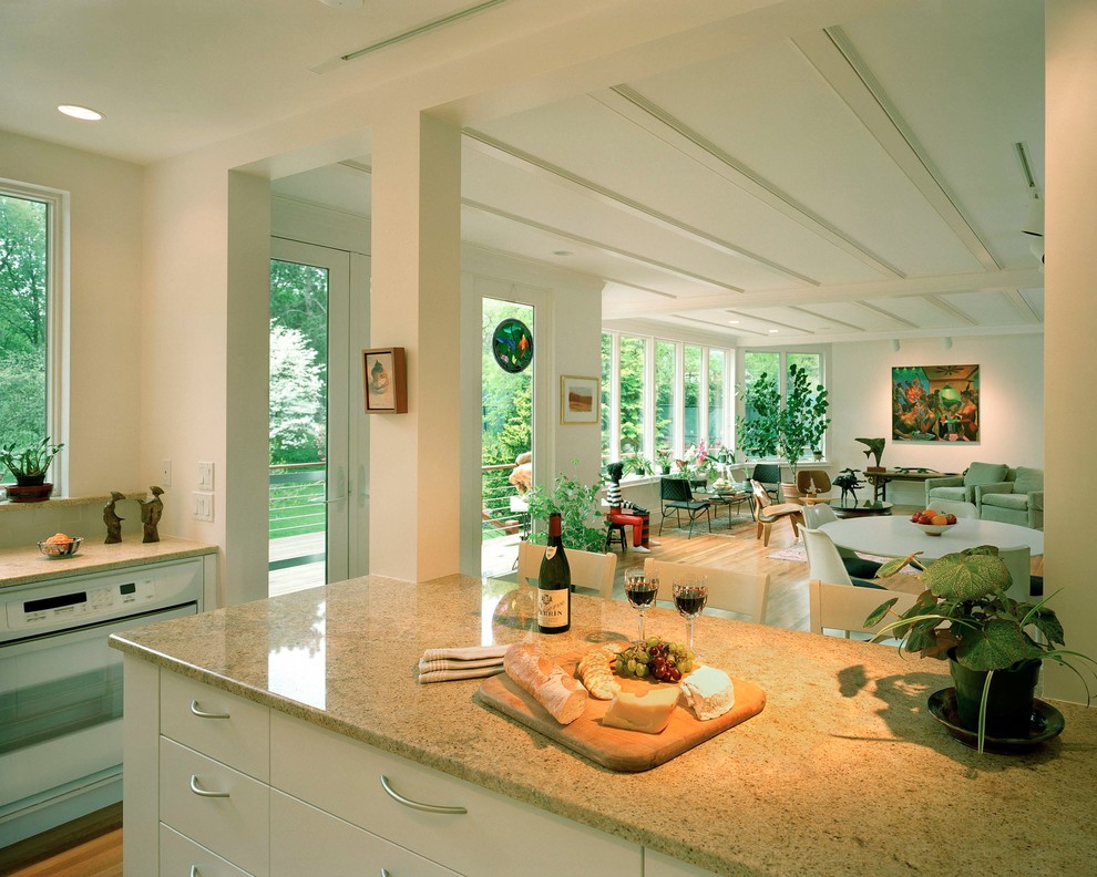 Example of a small trendy galley light wood floor and beige floor eat-in kitchen design in Boston with flat-panel cabinets, white cabinets, granite countertops, white backsplash, white appliances, a peninsula and beige countertops