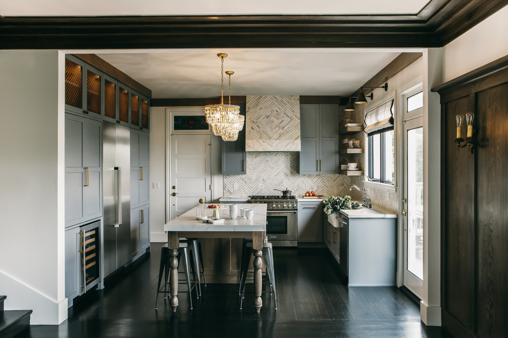 Inspiration for a medium sized traditional u-shaped kitchen/diner in San Francisco with a belfast sink, shaker cabinets, grey cabinets, engineered stone countertops, white splashback, marble splashback, stainless steel appliances, dark hardwood flooring, an island and black floors.