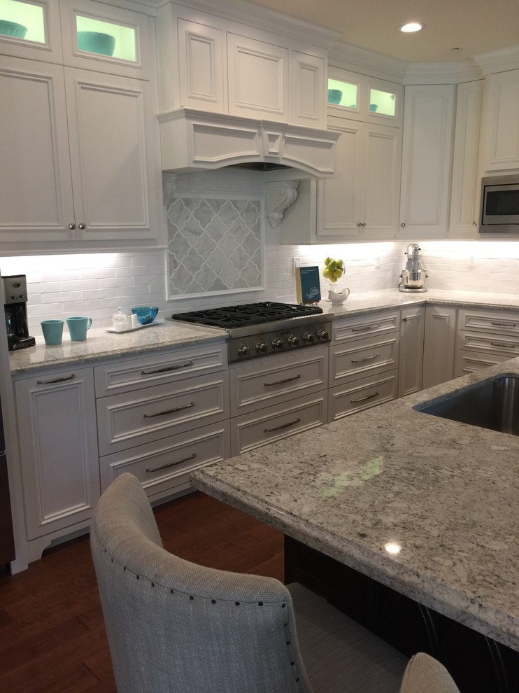 Medium sized traditional l-shaped kitchen in Portland with a submerged sink, recessed-panel cabinets, granite worktops, white splashback, ceramic splashback, stainless steel appliances and an island.