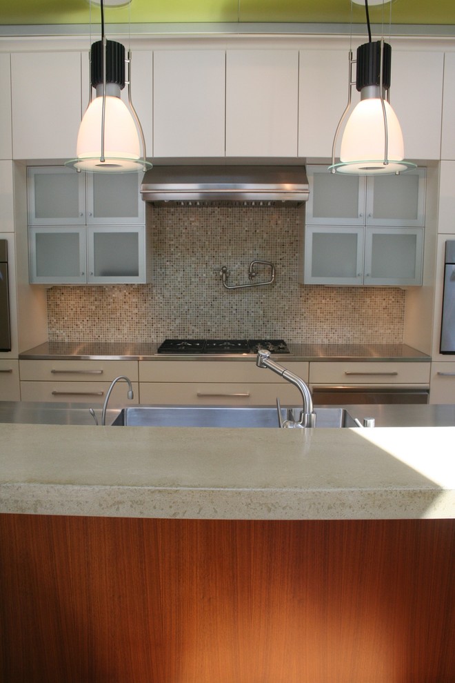 Immagine di una grande cucina moderna con lavello integrato, ante lisce, ante bianche, top in acciaio inossidabile, paraspruzzi con piastrelle a mosaico, elettrodomestici in acciaio inossidabile e penisola