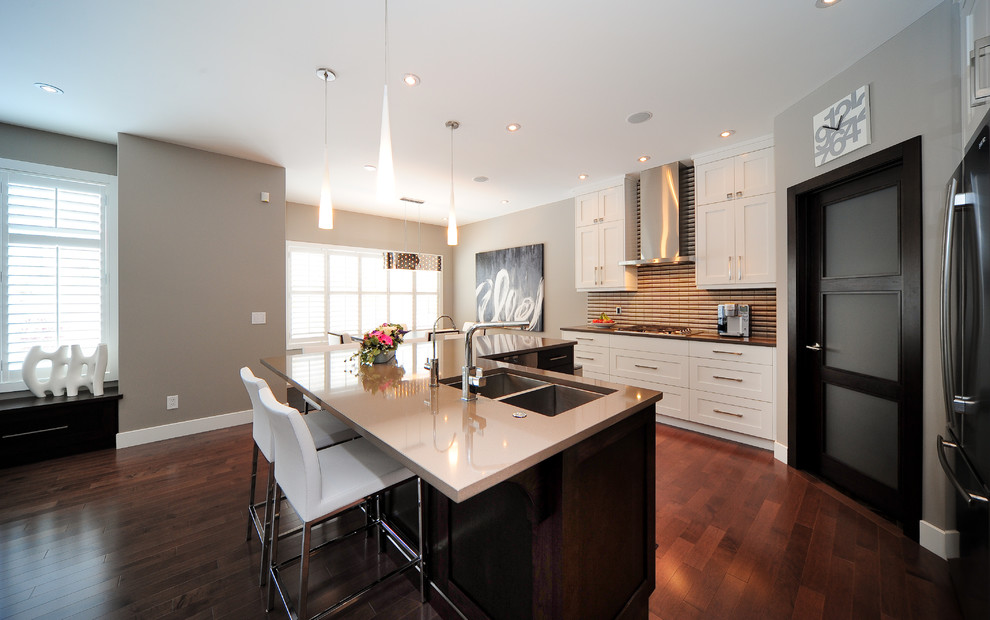 Contemporary kitchen in Calgary with shaker cabinets, white cabinets and beige splashback.