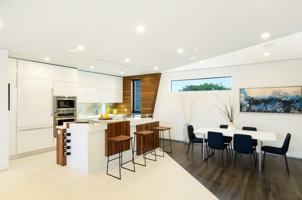 Mid-sized minimalist u-shaped white floor open concept kitchen photo in Los Angeles with flat-panel cabinets, white cabinets, quartzite countertops, stainless steel appliances, an island, white countertops, metallic backsplash and metal backsplash