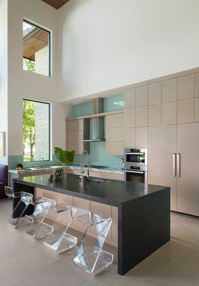 Contemporary l-shaped kitchen in Dallas with a submerged sink, flat-panel cabinets, medium wood cabinets, blue splashback, glass sheet splashback, integrated appliances and an island.