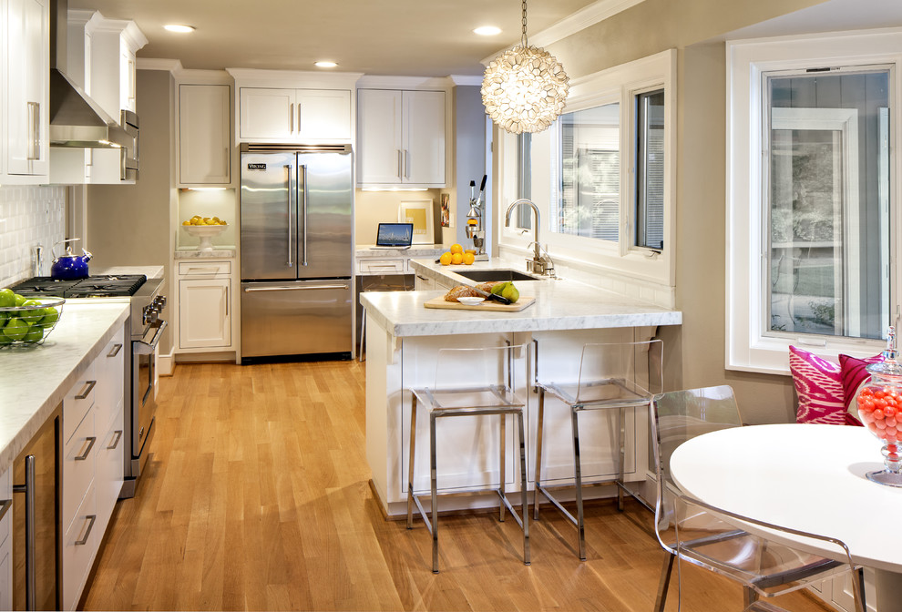 Ejemplo de cocina contemporánea con salpicadero de azulejos tipo metro, encimera de mármol y electrodomésticos de acero inoxidable