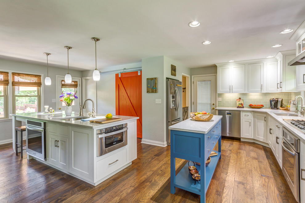 This is an example of a classic kitchen in Other with a submerged sink, shaker cabinets, white cabinets, stainless steel appliances, medium hardwood flooring and multiple islands.