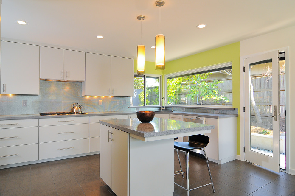 Пример оригинального дизайна: кухня в стиле модернизм с плоскими фасадами, белыми фасадами, фартуком цвета металлик и акцентной стеной