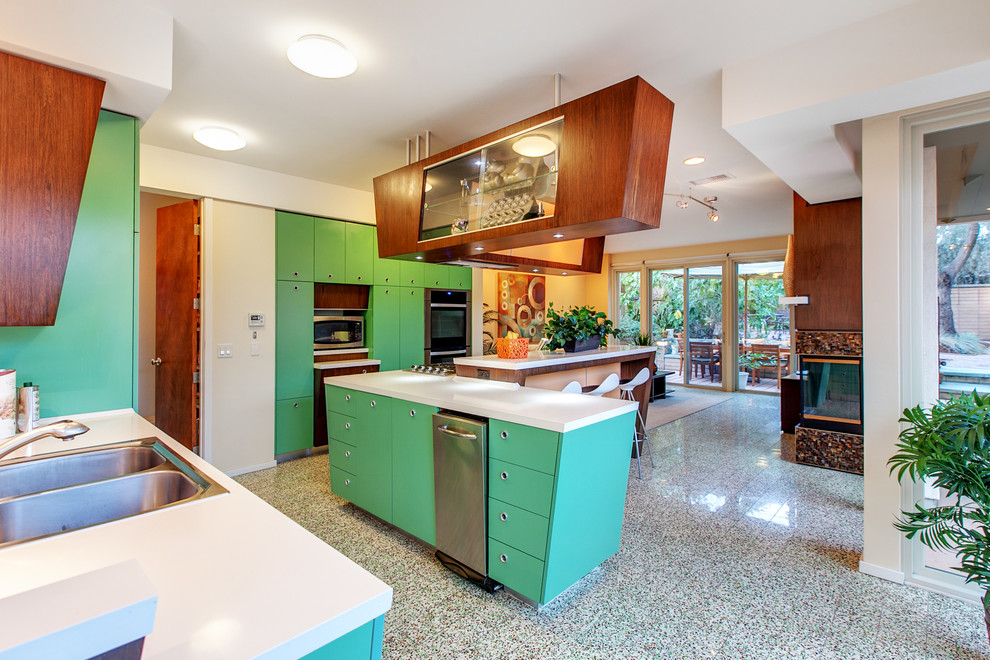 Modern inredning av ett kök, med en dubbel diskho, släta luckor, bänkskiva i kvarts, rostfria vitvaror och en köksö