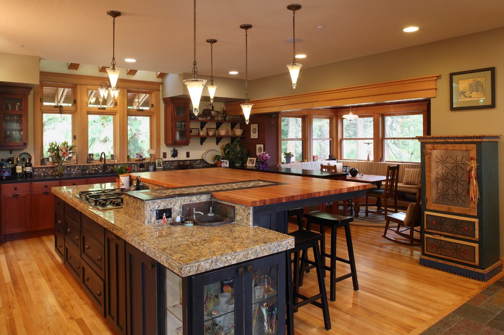 Example of a large arts and crafts l-shaped light wood floor and brown floor open concept kitchen design in Portland with shaker cabinets, medium tone wood cabinets, wood countertops, multicolored backsplash, an island, ceramic backsplash, an undermount sink and stainless steel appliances