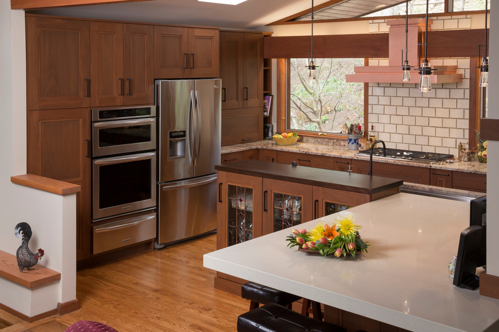 Exempel på ett avskilt amerikanskt linjärt kök, med en undermonterad diskho, skåp i shakerstil, skåp i mellenmörkt trä, bänkskiva i kvartsit, beige stänkskydd, glaspanel som stänkskydd och rostfria vitvaror