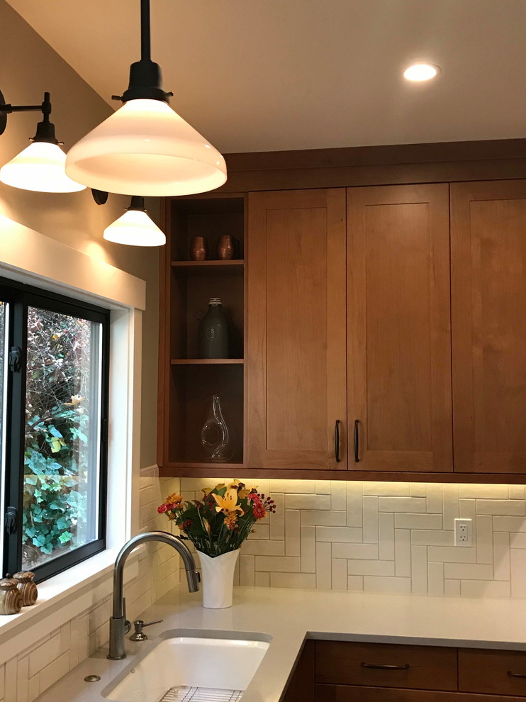 Example of a mid-sized arts and crafts u-shaped medium tone wood floor and brown floor open concept kitchen design in Seattle with an undermount sink, shaker cabinets, medium tone wood cabinets, quartz countertops, white backsplash, ceramic backsplash, stainless steel appliances, a peninsula and gray countertops