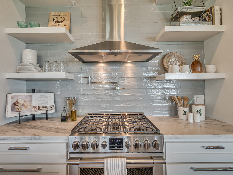 Foto på ett stort amerikanskt vit kök, med en undermonterad diskho, skåp i shakerstil, vita skåp, bänkskiva i kvartsit, grått stänkskydd, stänkskydd i keramik, rostfria vitvaror, klinkergolv i keramik, en köksö och grått golv