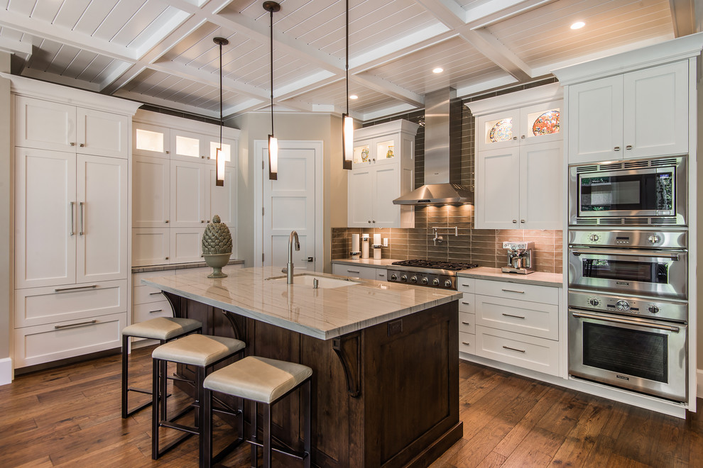 Example of an arts and crafts dark wood floor kitchen design in Salt Lake City with an undermount sink, shaker cabinets, white cabinets, quartz countertops, gray backsplash, porcelain backsplash and an island