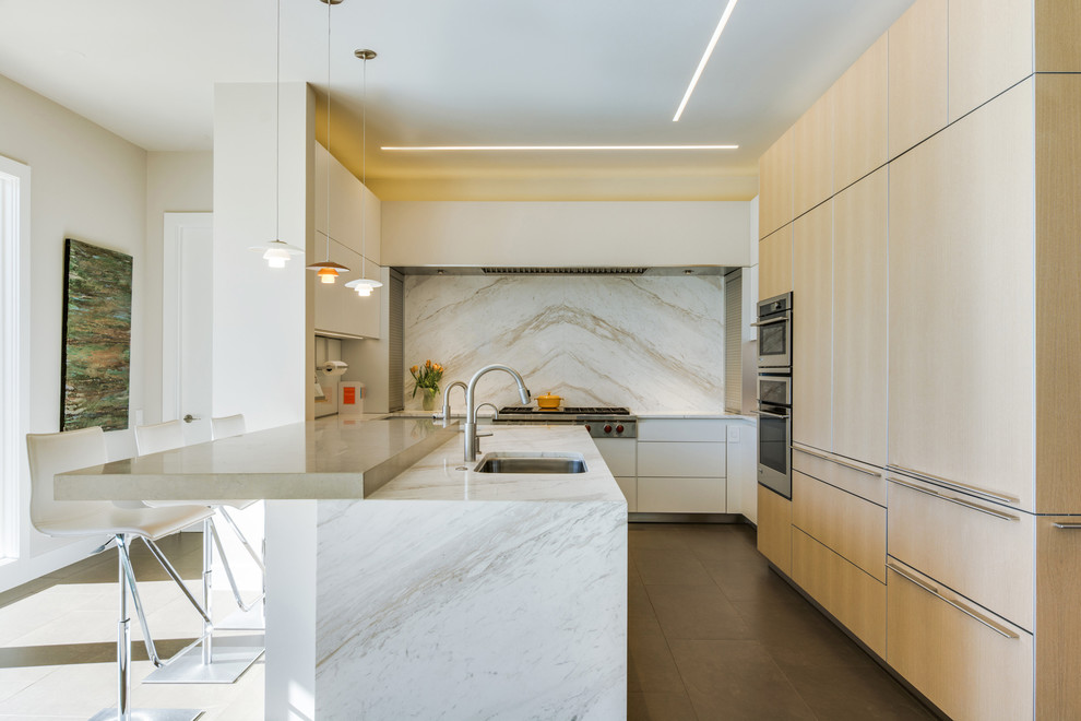 Inspiration for a large modern l-shaped kitchen/diner in Dallas with a submerged sink, flat-panel cabinets, light wood cabinets, marble worktops, white splashback, stone slab splashback, stainless steel appliances, ceramic flooring and a breakfast bar.