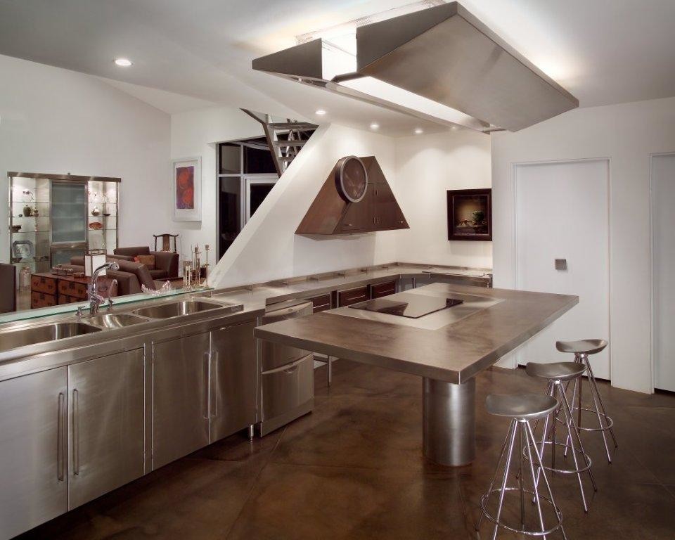 Foto på ett funkis kök, med en trippel diskho, skåp i mörkt trä, bänkskiva i rostfritt stål, vitt stänkskydd, rostfria vitvaror och en köksö
