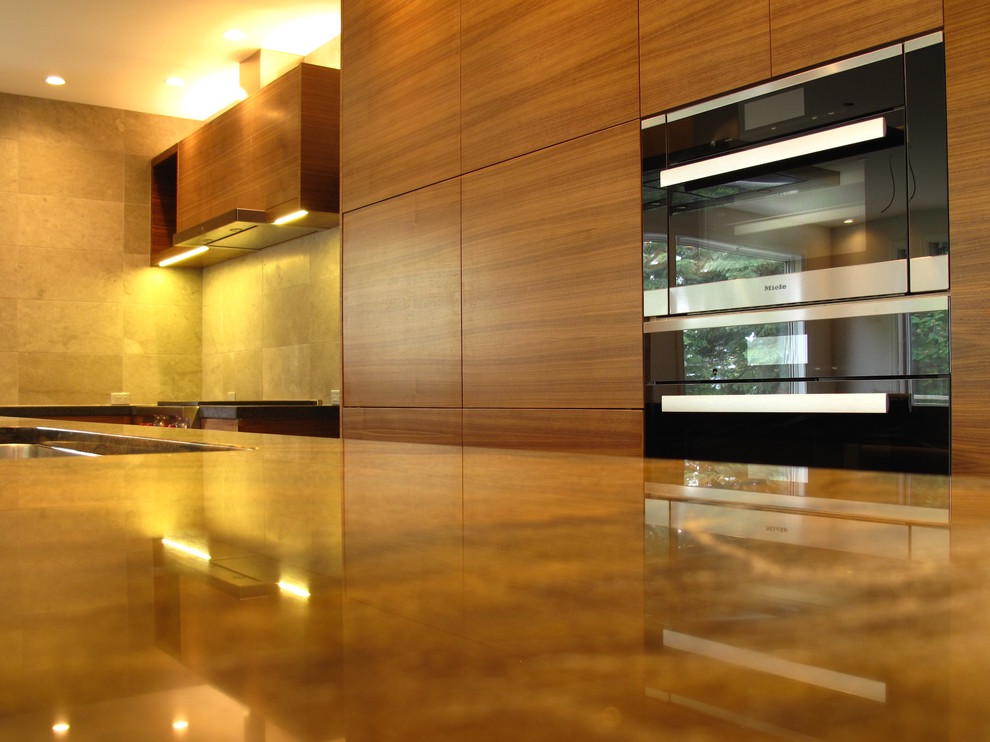 Idee per una cucina minimalista con ante lisce, ante in legno scuro, top in marmo, paraspruzzi beige, elettrodomestici in acciaio inossidabile e pavimento in legno massello medio