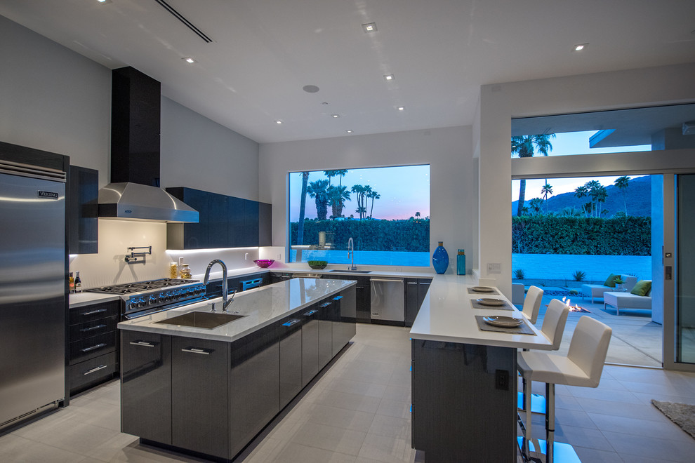 Immagine di una grande cucina moderna con ante lisce, ante grigie, top in marmo, paraspruzzi bianco e elettrodomestici in acciaio inossidabile