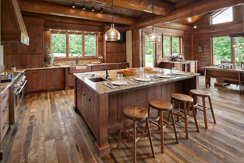 Urige Küche in L-Form mit flächenbündigen Schrankfronten, hellbraunen Holzschränken, Küchengeräten aus Edelstahl, braunem Holzboden, Kücheninsel, Landhausspüle und Granit-Arbeitsplatte in Boise