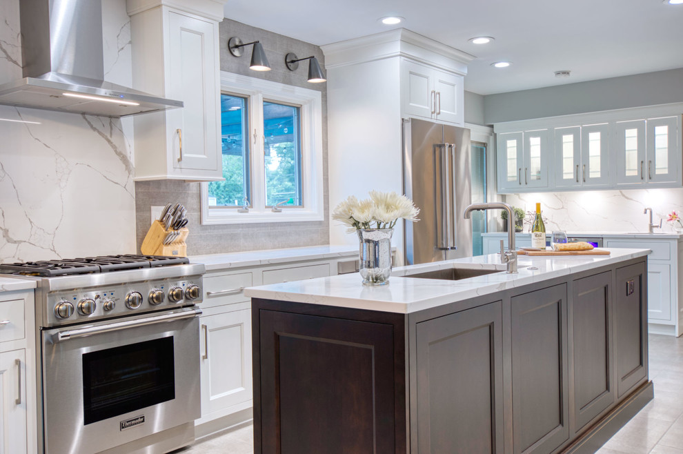 Inspiration for a large classic galley kitchen/diner in Chicago with a submerged sink, beaded cabinets, white cabinets, engineered stone countertops, multi-coloured splashback, stone slab splashback, stainless steel appliances, porcelain flooring, an island, grey floors and white worktops.