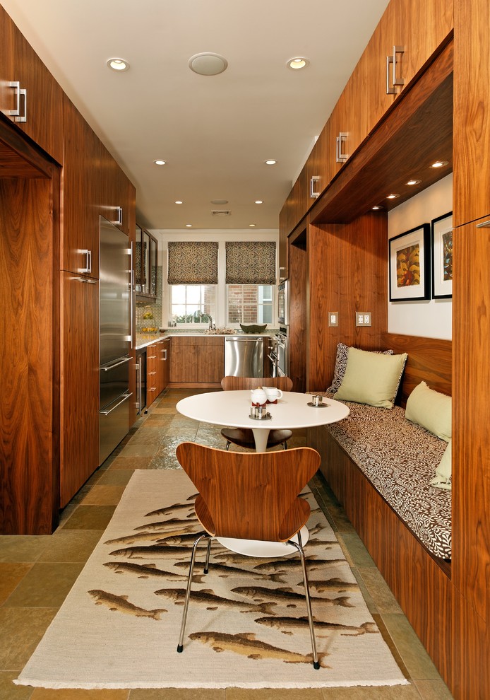 На фото: п-образная, отдельная кухня в современном стиле с техникой из нержавеющей стали, плоскими фасадами и фасадами цвета дерева среднего тона
