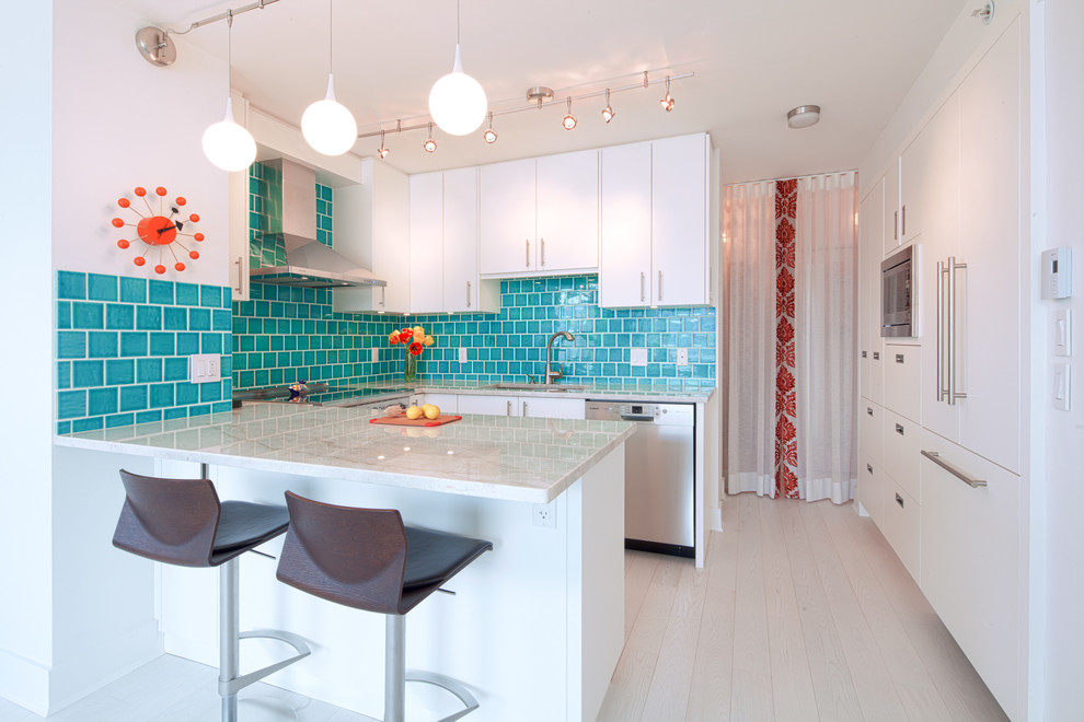 Exempel på ett litet klassiskt kök, med en dubbel diskho, släta luckor, vita skåp, granitbänkskiva, blått stänkskydd, stänkskydd i keramik, rostfria vitvaror, klinkergolv i porslin och en halv köksö