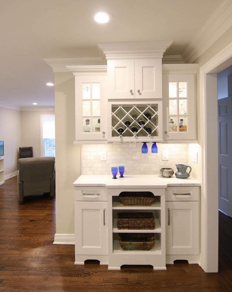 Example of a large minimalist l-shaped dark wood floor and brown floor eat-in kitchen design in New York with an undermount sink, shaker cabinets, white cabinets, quartzite countertops, gray backsplash, marble backsplash, stainless steel appliances and an island