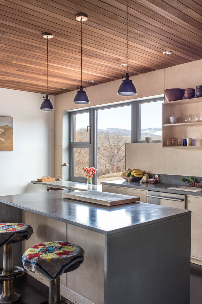 Example of a mid-sized danish l-shaped concrete floor and gray floor open concept kitchen design in Other with an undermount sink, flat-panel cabinets, light wood cabinets, concrete countertops, black backsplash, wood backsplash, stainless steel appliances and an island