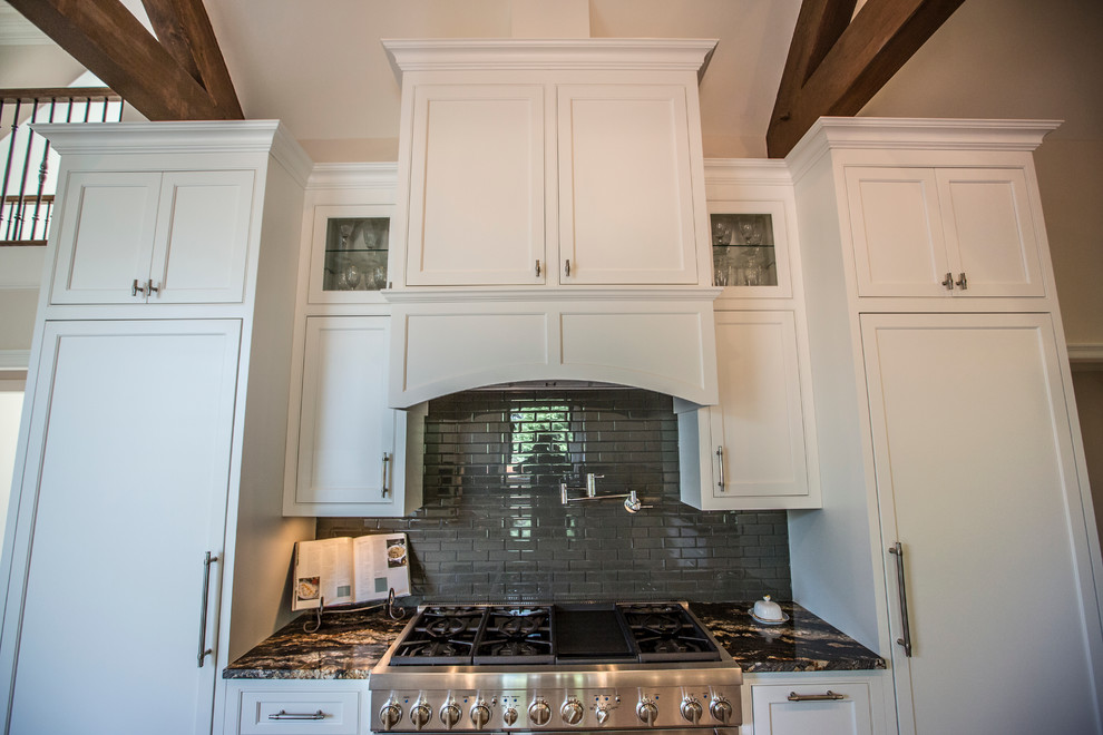 Large transitional medium tone wood floor eat-in kitchen photo in Atlanta with an undermount sink, recessed-panel cabinets, white cabinets, granite countertops, black backsplash, glass tile backsplash, stainless steel appliances and an island