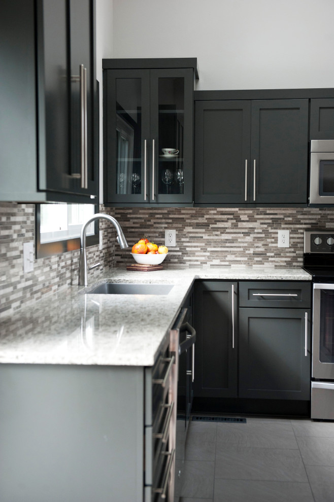 Inspiration for a large modern l-shaped ceramic tile and gray floor eat-in kitchen remodel in Other with an undermount sink, shaker cabinets, black cabinets, granite countertops, multicolored backsplash, mosaic tile backsplash, stainless steel appliances, an island and white countertops