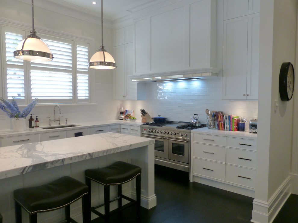 Photo of a large classic l-shaped open plan kitchen in Adelaide with a submerged sink, white cabinets, marble worktops, white splashback, shaker cabinets, ceramic splashback, stainless steel appliances, porcelain flooring, an island and black floors.