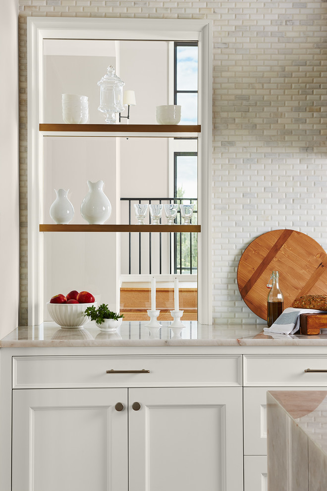 Design ideas for an expansive traditional single-wall kitchen pantry in Minneapolis with a belfast sink, flat-panel cabinets, white cabinets, quartz worktops, white splashback, marble splashback, integrated appliances, light hardwood flooring, an island and brown floors.