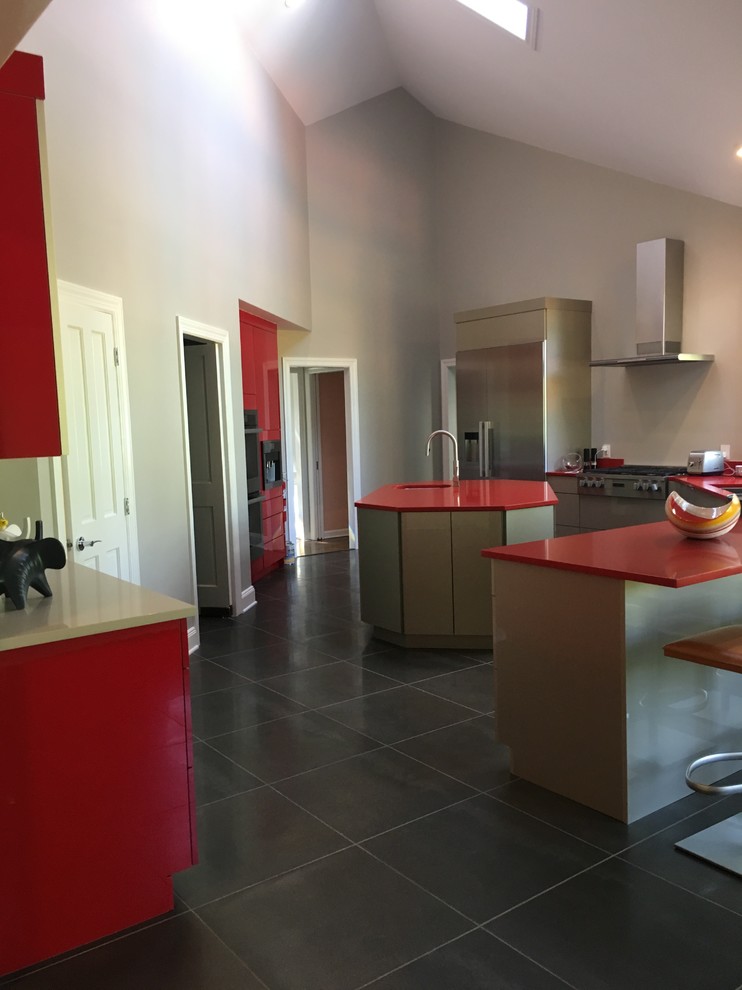Esempio di una grande cucina minimalista con lavello sottopiano, ante lisce, ante rosse, top in quarzo composito, paraspruzzi rosso, elettrodomestici in acciaio inossidabile e pavimento grigio