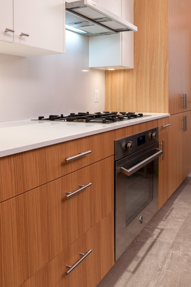Bild på ett mellanstort funkis kök, med en undermonterad diskho, släta luckor, skåp i mellenmörkt trä, bänkskiva i kvarts, grått stänkskydd, stänkskydd i sten, rostfria vitvaror, klinkergolv i keramik och en köksö