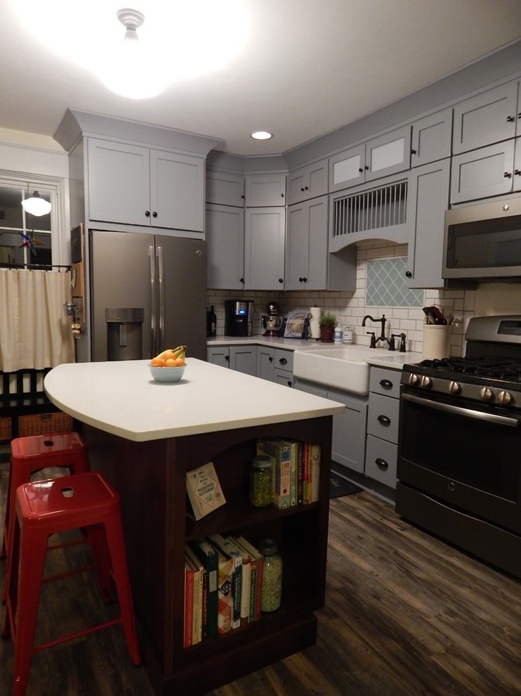 Foto på ett litet, avskilt lantligt l-kök, med en rustik diskho, släta luckor, grå skåp, bänkskiva i kvarts, vitt stänkskydd, stänkskydd i tunnelbanekakel, linoleumgolv, en köksö och rostfria vitvaror