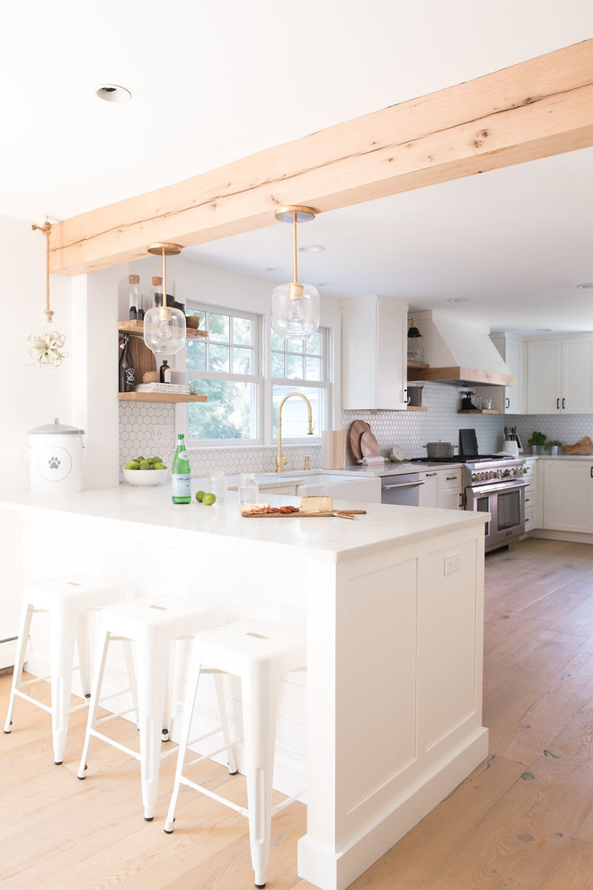 Eat-in kitchen - large farmhouse u-shaped light wood floor and brown floor eat-in kitchen idea in Boston with shaker cabinets, white cabinets, quartz countertops, white backsplash, mosaic tile backsplash, stainless steel appliances, a peninsula and white countertops