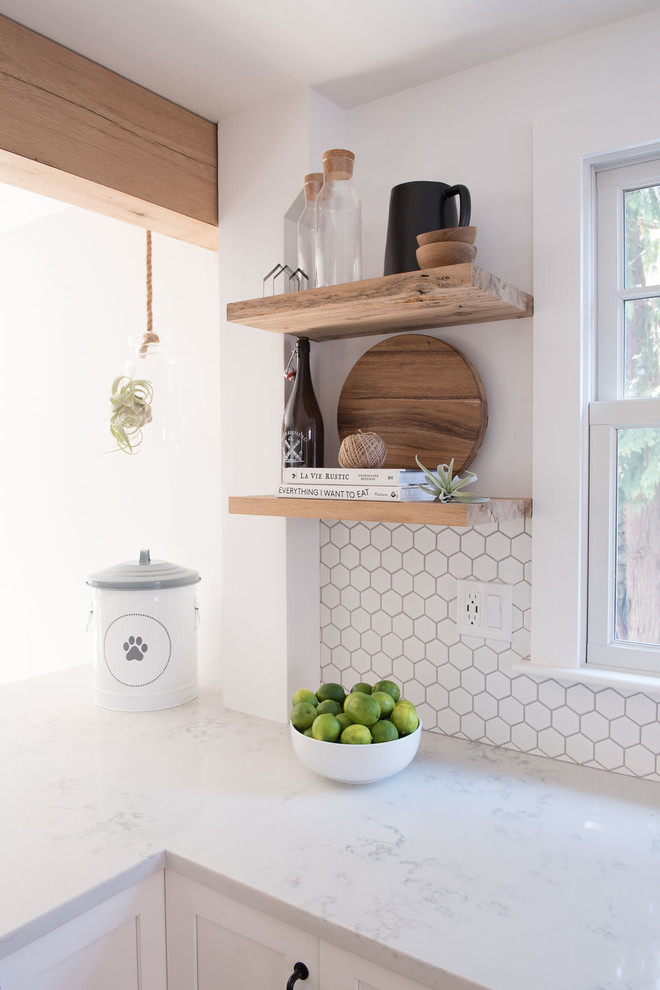 Example of a large cottage u-shaped light wood floor and brown floor eat-in kitchen design in Boston with shaker cabinets, white cabinets, quartz countertops, white backsplash, mosaic tile backsplash, stainless steel appliances, a peninsula and white countertops