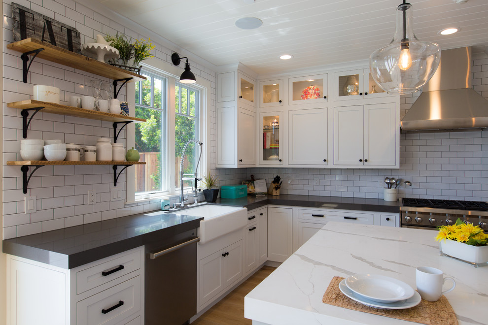 サンフランシスコにある高級な中くらいなカントリー風のおしゃれなキッチン (エプロンフロントシンク、白いキッチンパネル、磁器タイルのキッチンパネル、シルバーの調理設備、ベージュの床) の写真