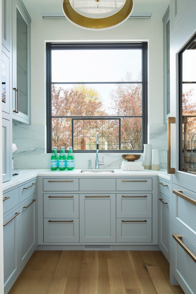 Aménagement d'une arrière-cuisine classique en U avec un évier encastré, un placard à porte shaker, fenêtre, parquet clair, un sol beige et fenêtre au-dessus de l'évier.