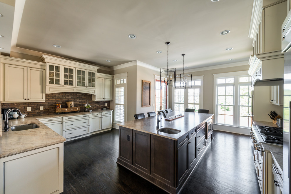 Mid-sized country u-shaped dark wood floor eat-in kitchen photo in Atlanta with recessed-panel cabinets, white cabinets, granite countertops, brown backsplash, brick backsplash, stainless steel appliances, an island and an undermount sink