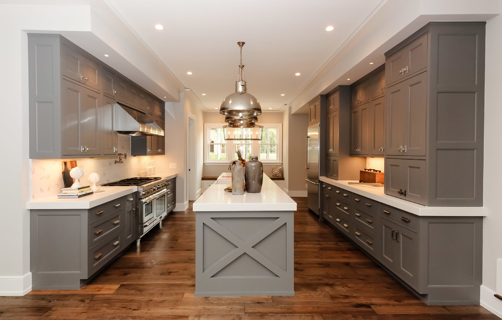 Example of a mid-sized farmhouse galley medium tone wood floor kitchen design in Raleigh with shaker cabinets, gray cabinets, white backsplash, stainless steel appliances, an island, a farmhouse sink and solid surface countertops