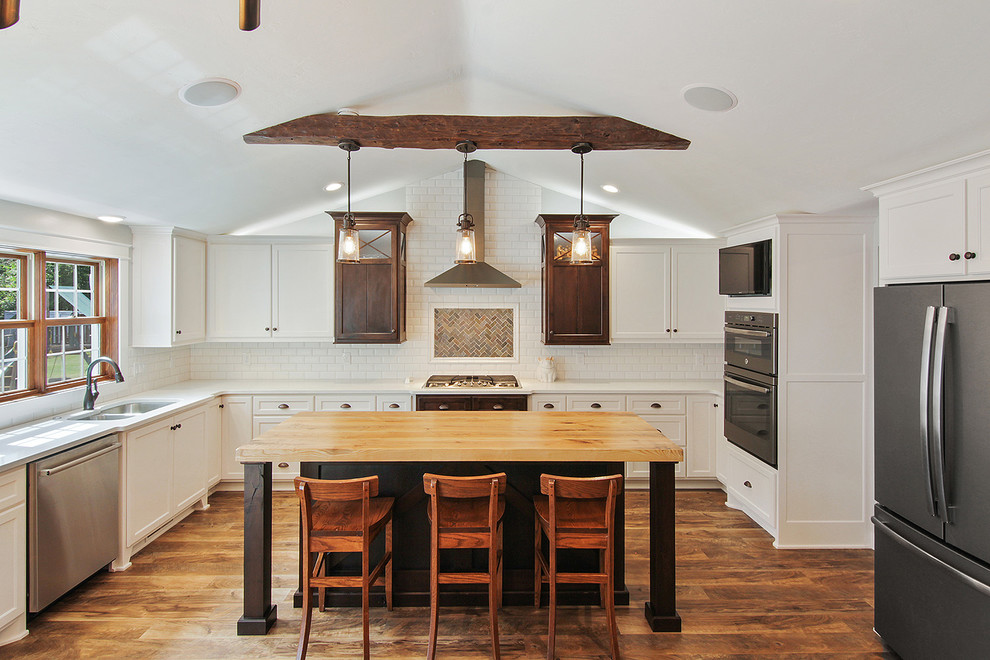 Exempel på ett lantligt l-kök, med en undermonterad diskho, vita skåp, bänkskiva i kvarts, rostfria vitvaror, vinylgolv, en köksö, brunt golv, luckor med infälld panel, vitt stänkskydd och stänkskydd i tegel