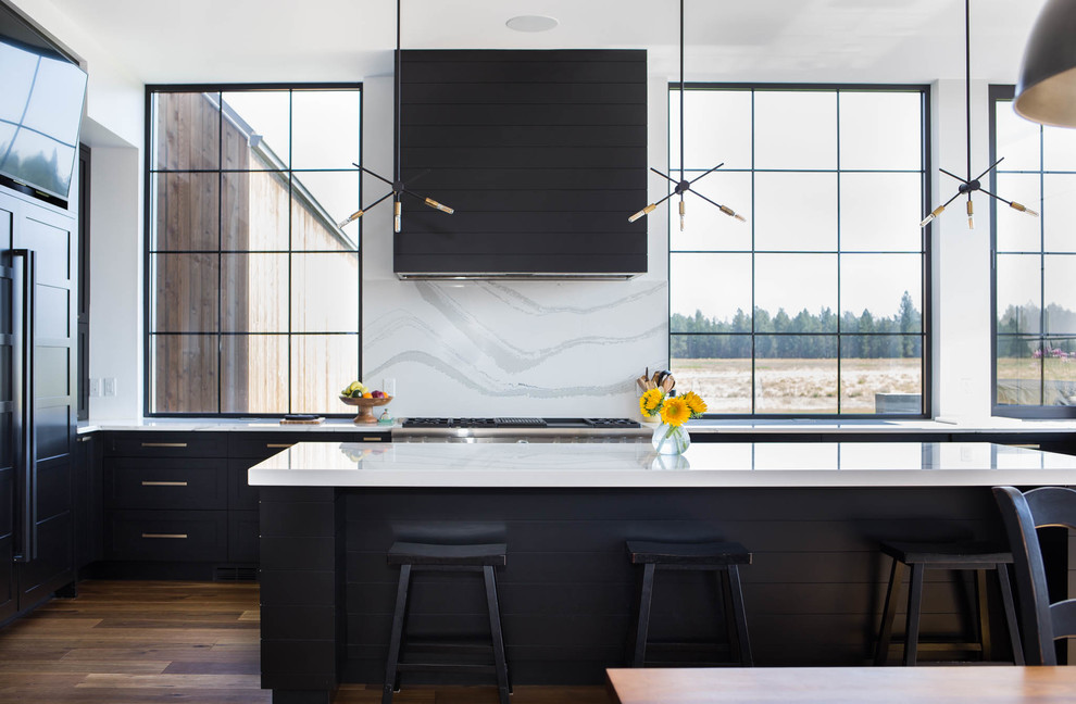 Eat-in kitchen - large modern u-shaped medium tone wood floor eat-in kitchen idea in Seattle with an undermount sink, recessed-panel cabinets, black cabinets, marble countertops, white backsplash, marble backsplash, stainless steel appliances, an island and white countertops