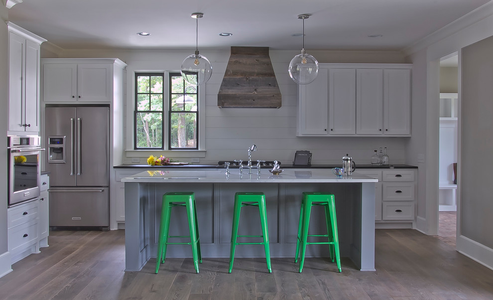 Inspiration for a mid-sized cottage single-wall medium tone wood floor open concept kitchen remodel in Atlanta with a farmhouse sink, shaker cabinets, white cabinets, marble countertops, white backsplash, wood backsplash, stainless steel appliances and an island