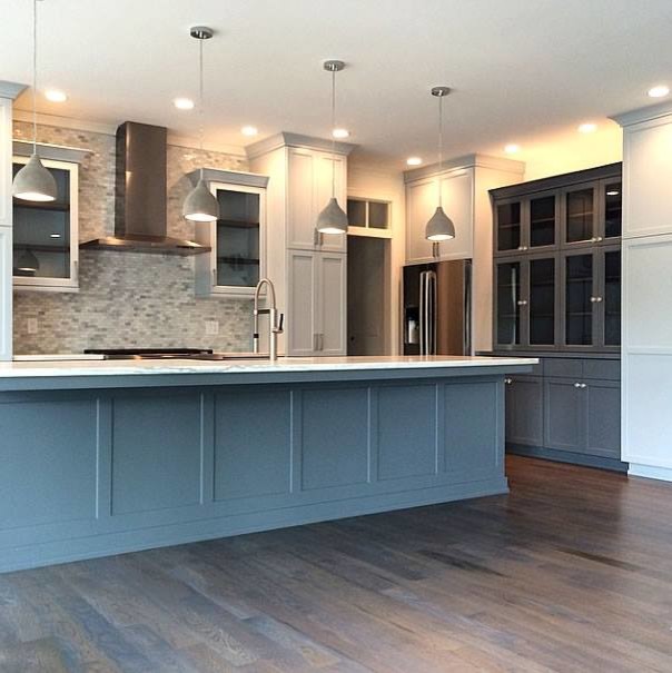 Eat-in kitchen - large transitional l-shaped brown floor eat-in kitchen idea in Milwaukee with a farmhouse sink, glass-front cabinets, white cabinets, gray backsplash, mosaic tile backsplash, stainless steel appliances, an island and white countertops