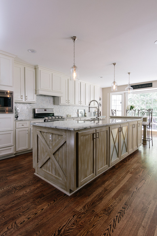 Photo of a large traditional galley kitchen in Atlanta with a submerged sink, shaker cabinets, white cabinets, granite worktops, white splashback, stone tiled splashback, stainless steel appliances, medium hardwood flooring and an island.