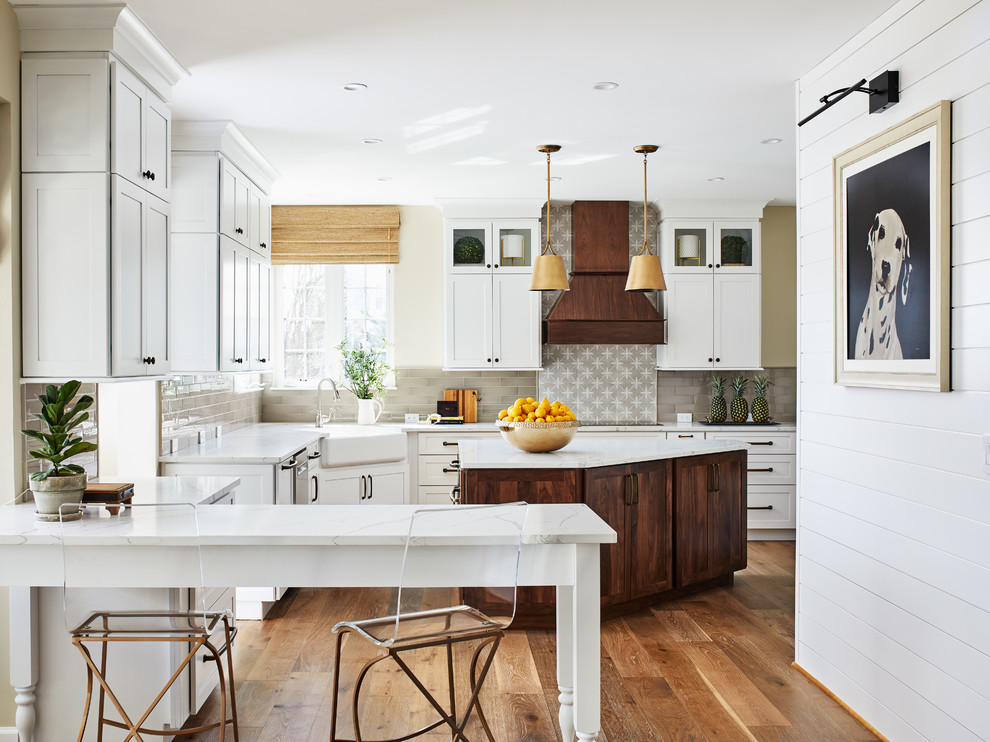 Design ideas for a rural enclosed kitchen in DC Metro with a belfast sink, shaker cabinets, white cabinets, grey splashback, metro tiled splashback, medium hardwood flooring, an island and white worktops.